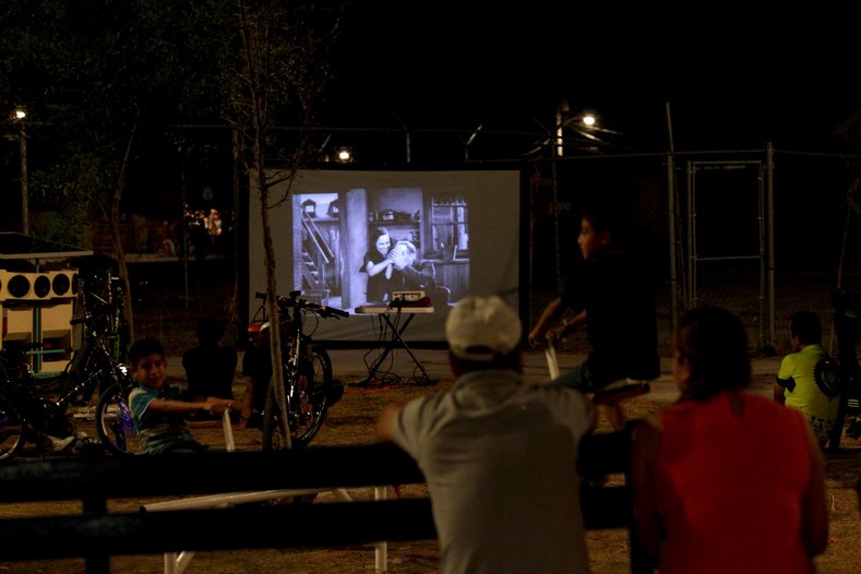 Residents watch a film projected by the Cinecleta, Moviebike, at a park in Saltillo