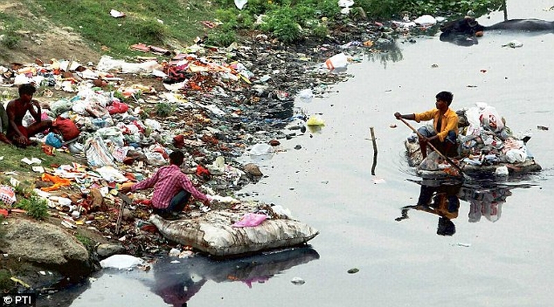 Rag pickers search for valuables in the Yamuna River in New Delhi