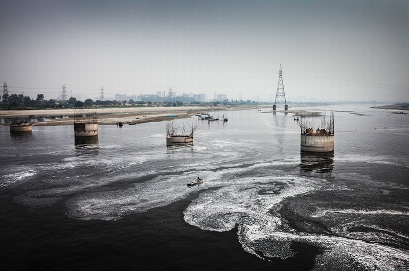 A fisherman tries to catch fish in the dirty, black waters of the river Yamuna at the Okhla Barrage, New Delhi on September 14, 2013. Waste Water, poisonous chemicals, and toxic metals from 26 major sewers and industries are discharged into the river everyday, due to which a holy river has become the biggest drain of India. After the failure of Yamuna Action Plan 1 and 2, the government has invested approximately 1600 crores in Yamuna Action Plan 3 to clean the river.