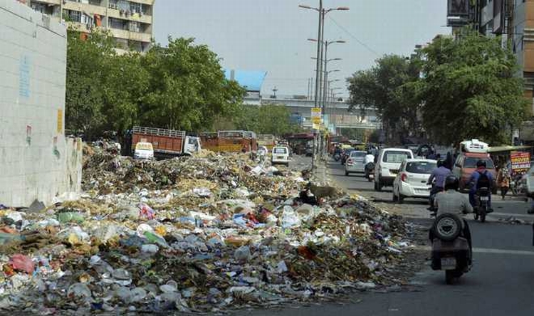 New Delhi : Garbage dumped on road near Nirman Vihar metro station as MCD workers went on strike due to non-payment of salaries in New Delhi on Friday . PTI Photo (PTI6_12_2015_000170B)