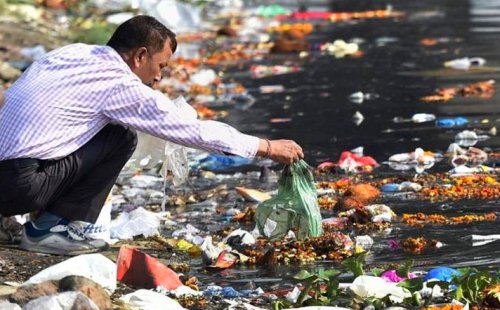 A-man-throws-the-puja-offerings-in-Yamuna-River-at-the-end-of-Navratri-festival-in-New-Delhi