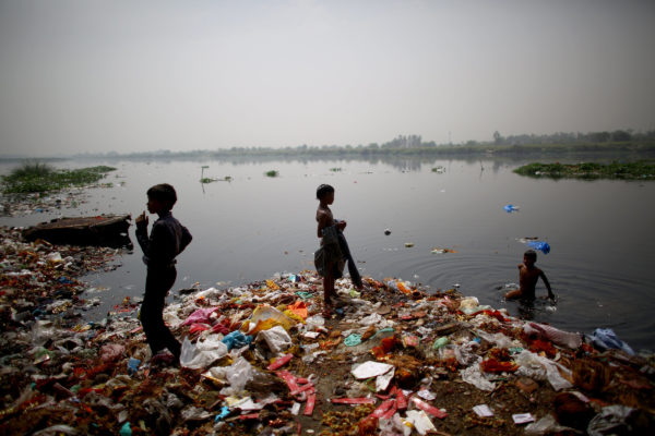 Children who live along the banks of the Yamuna River in ramshackle huts hunt for coins and anything valuable they can collect