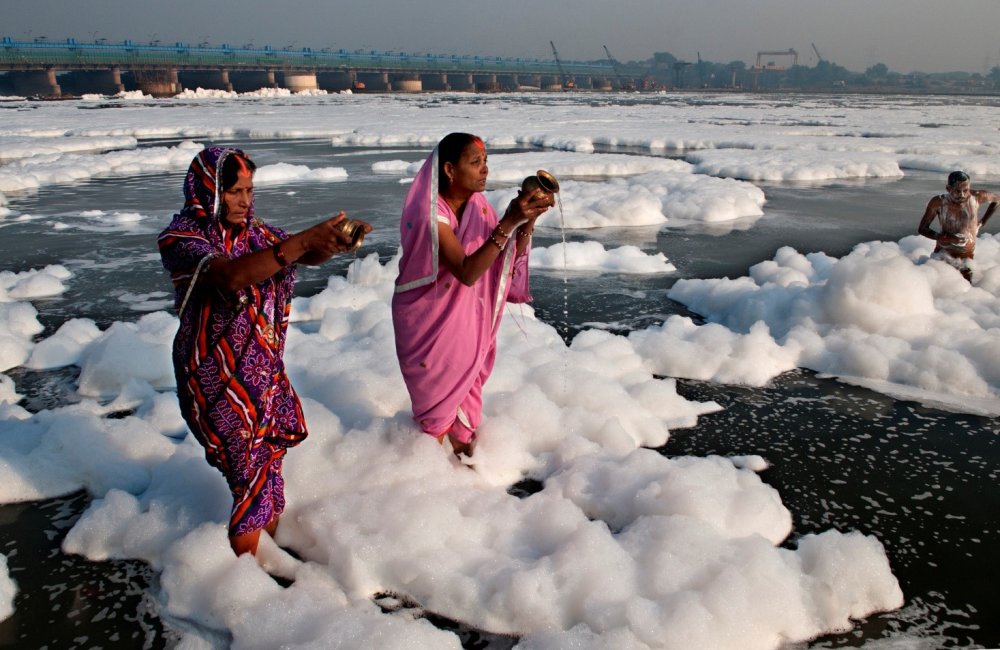 Hindu women perform their morning ritual in the highly polluted Yamuna River in delhi