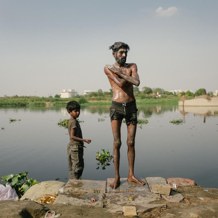 Man and child bathe in the Yamuna River