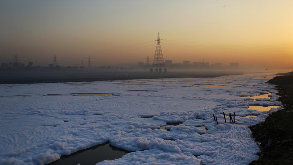 Thick foam flows down the polluted Yamuna river in New Delhi at daw
