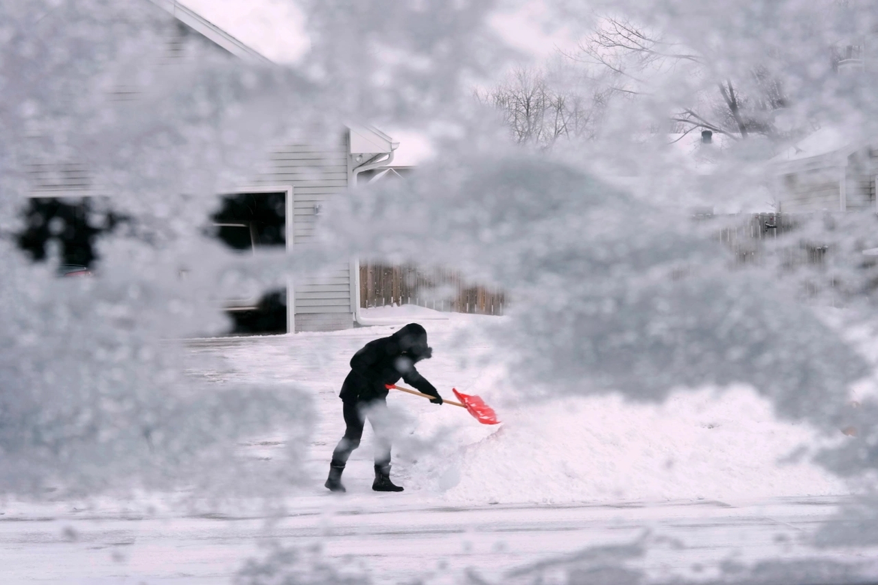 A resident of Urbandale, Iowa, shovels snow off the end of a driveway