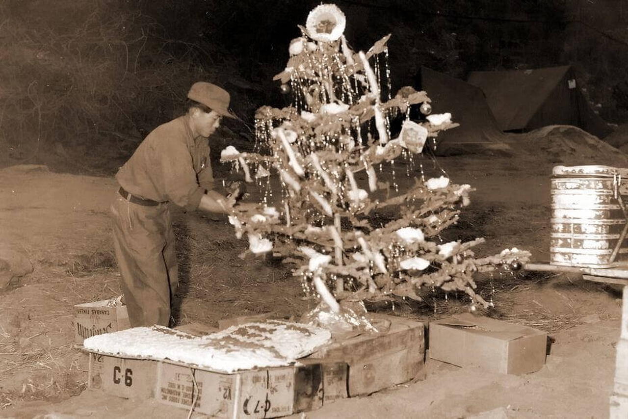 Korean soldier decorates the Christmas tree amid war